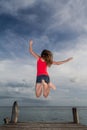 Young woman jumping at the pier Royalty Free Stock Photo