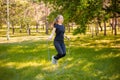 Young woman jumping rope on the lawn in a summer park. Jumping model. The concept of a healthy lifestyle and outdoor sports Royalty Free Stock Photo