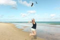 Young woman jumping smiling on the beach sand by the sea Royalty Free Stock Photo