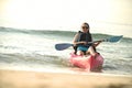 Young woman in kayak on beach during summer