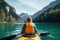 Young woman kayaking on the lake in the mountains. Active lifestyle, Beautiful woman kayaking on a beautiful mountain lake with