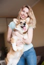 Young woman keeping welsh corgi puppy near her face. Welsh Corgi Pembroke puppy, happy cute dog Royalty Free Stock Photo