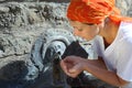 Young woman in kerchief drinking water