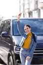 Young woman with key near car on street. Buying new auto Royalty Free Stock Photo