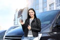 Young woman with key near car on street. Buying new auto Royalty Free Stock Photo