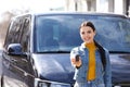 Young woman with key near car on street. Buying new auto Royalty Free Stock Photo