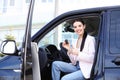 Young woman with key sitting in car. Buying new auto Royalty Free Stock Photo