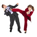 Young woman kicks man in business suit Royalty Free Stock Photo