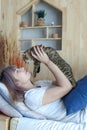 Young woman kissing a pussycat. A cat lying on a person. Asian young woman with cute cat lying in sofabed at home Royalty Free Stock Photo