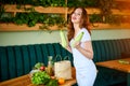 Young woman at kitchen taking out zucchini from grocery shopping paper bag with fruits and vegetables products Royalty Free Stock Photo