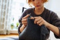 young woman knits wool product