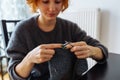 young woman knits wool product