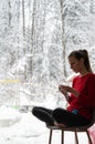 Young woman knitting by the window