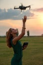 Young woman landing a drone in her hand