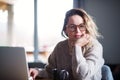 Young woman with laptop and coffee relaxing indoors at home.