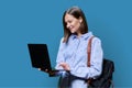 Young woman with laptop computer in hands on blue background Royalty Free Stock Photo