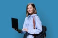 Young woman with laptop computer in hands on blue background Royalty Free Stock Photo