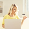 Young woman with a laptop holding a credit card Royalty Free Stock Photo