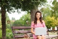 Young woman with laptop resting on bench in park Royalty Free Stock Photo