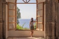 Young woman at a large open window.