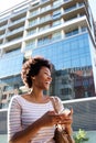 Young woman laughing with cell phone and purse in the city Royalty Free Stock Photo