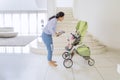 Young woman laughing with her baby in a stroller Royalty Free Stock Photo