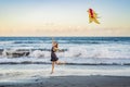 A young woman launches a kite on the beach. Dream, aspirations, future plans