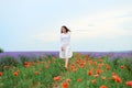 Young woman is in the lavender field, beautiful summer landscape with red poppy flowers Royalty Free Stock Photo