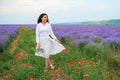 Young woman is in the lavender field, beautiful summer landscape with red poppy flowers Royalty Free Stock Photo