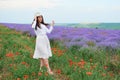 Young woman is in the lavender field, beautiful summer landscape with red poppy flowers Royalty Free Stock Photo