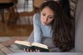 Young woman laying on the couch and reading an interesting book Royalty Free Stock Photo