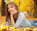 Young Woman Laying Down On The Ground In Autumn Park, beauty girl in fall forest Royalty Free Stock Photo