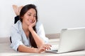 Young woman laying on floor with laptop