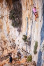 Young woman lead climbing on natural cliff