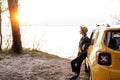 Young Woman Lean against Car at Sea Shore Sunset Royalty Free Stock Photo