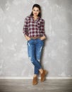 Young woman leaning against a gray wall looking at camera Royalty Free Stock Photo