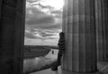 Young woman is leaning against a pillar and looking into the horizon Royalty Free Stock Photo
