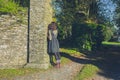 Young woman leaning against stone wall