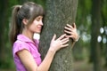 Young woman leaning to tree trunk in summer forest Royalty Free Stock Photo