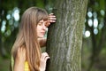 Young woman leaning to tree trunk in summer forest Royalty Free Stock Photo