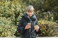 young woman leaning on wooden fence and using her cell phone Royalty Free Stock Photo