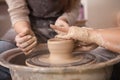 Young woman learning from professional potter