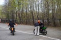 A young woman is learning to ride a motorbike in a motorcycle school. She is taught by a teacher