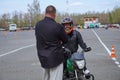 A young woman is learning to ride a motorbike in a motorcycle school. She is taught by a teacher