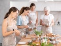 Young woman learns to cook at master class