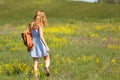 Young woman with a leather backpack in a summer field Royalty Free Stock Photo