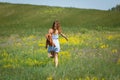 Young woman with a leather backpack in a summer field Royalty Free Stock Photo