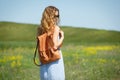 Young woman with a leather backpack in a summer field Royalty Free Stock Photo