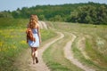 Young woman with a leather backpack on a summer rural road Royalty Free Stock Photo