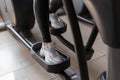 Young woman in leggings in sports sneakers does cardio training on a stepper simulator in the gym. Girl burns calories. Closeup Royalty Free Stock Photo